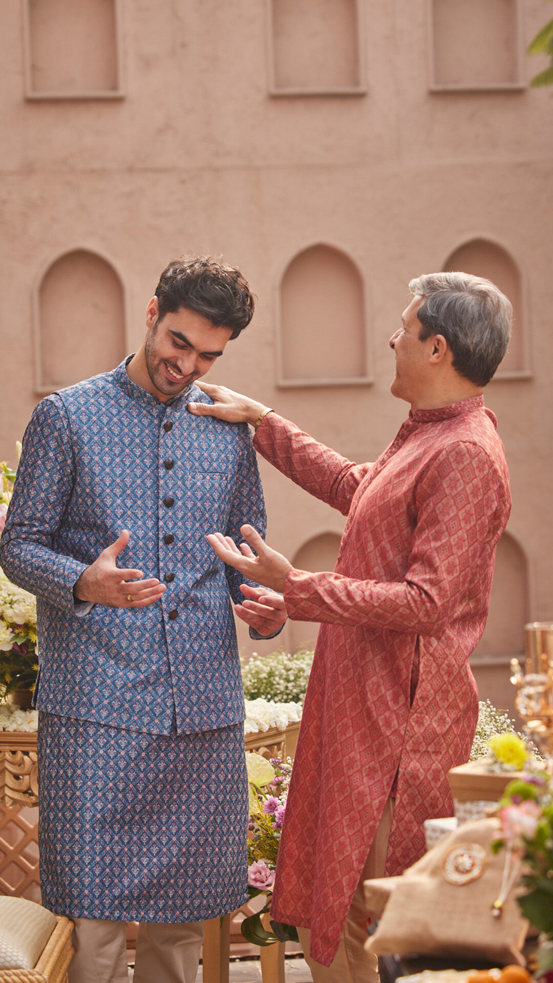 Father proudly placing a hand on his son's shoulder, celebrating the family's Roka ceremony.
